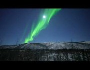 منظر بديع للشفق القطبي مع ضوء القمر في سماء ألاسكا