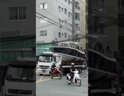 شاحنة تحمل قارباً تجتاز بصعوبة أسلاكاً كهربائية بالبرازيل