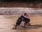 فيديو.. مواطن ينقذ مسناًً علقت سيارته وسط مياه سيول بضباء