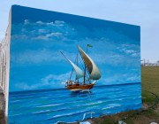 بدعم من بلدية القطيف فنان تشكيلي يرسم لوحة فنية عن الموروث الشعبي على أحد جداريات الواجهة البحرية