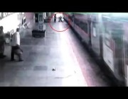 رجل ينزلق عند صعوده إلى قطار متحرك والشرطي ينقذه