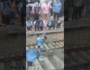 شاب ينقذ عجوزاً صينية بعد سقوطها على قضبان القطار