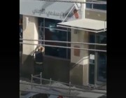 أردني غاضب يحطم واجهة بنك في عمان.. والشرطة تلقي القبض عليه (فيديو)