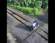 نجاة إندونيسية وطفليها من دهس القطار بعد أن علقت دراجتهم النارية في طريقه