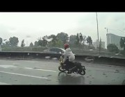قائد دراجة نارية ينجو بأعجوبة من الدهس تحت عجلات شاحنة في ماليزيا
