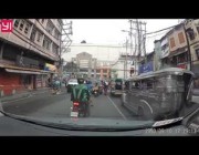 سائق سيارة يدفع أخرى أمامه ليتمكن من المرور هو وراكبو الدراجات النارية في مانيلا