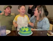 طفل يغمس وجهه في كعكة عيد ميلاده بسعادة كبيرة