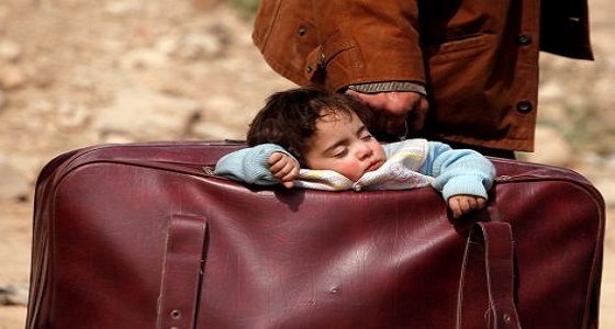 شاهد.. طفلة سورية نائمة في حقيبة والدها الفار من ” الغوطة “