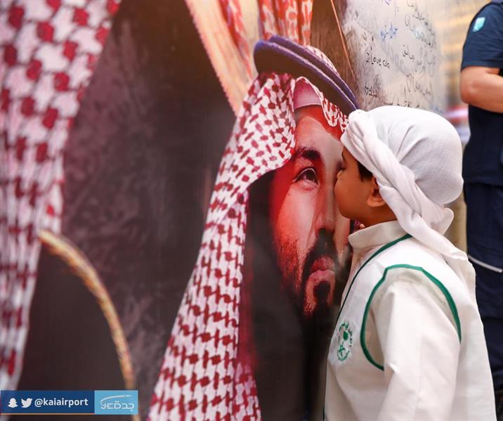 طفل يقبّل صورة ولي العهد في مطار الملك عبدالعزيز بجدة