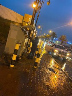 صورة لفني كهرباء يعمل تحت الأمطار بجازان لضمان استمرار الخدمة