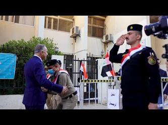 شرطي يفتش رئيس الوزراء العراقي قبل دخوله لمركز اقتراع في بغداد