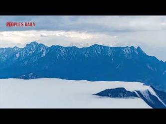 تدفق السحب البيضاء لأسفل كالشلال يرسم لوحة طبيعية جميلة بجبال الصين