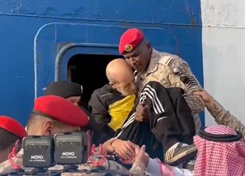 عسكري سعودي يحمل مسنًا وينزله من سفينة الإجلاء السعودية القادمة من السودان
